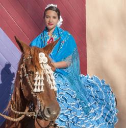 Alexina García Chávez rides side saddle on top of Poesía in the manner of the feria de abril (April Fair). 